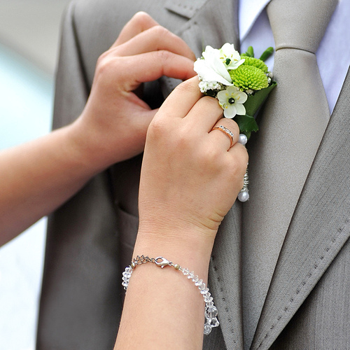 Wedding boutonniere placed on jacket of groom