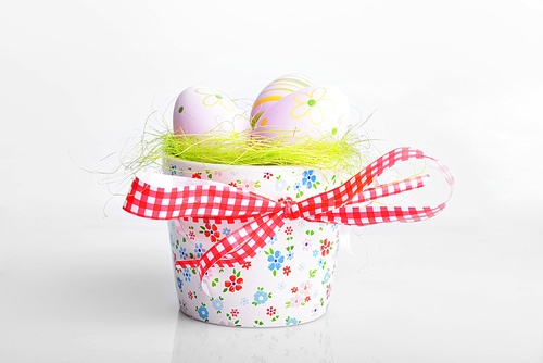 painted easter eggs on green in decorative bowl