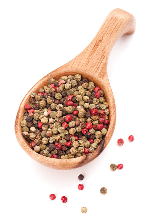 Black, green and pink pepper peppercorn mix in wooden spoon isolated on white cutout