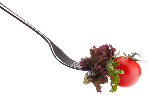 Fresh salad and cherry tomato on fork isolated on white cutout. Healthy eating concept.