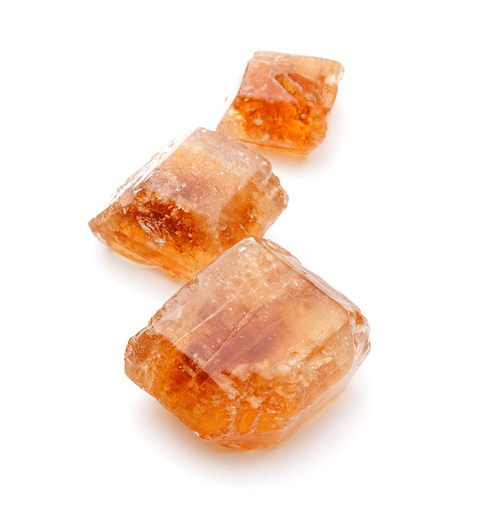 Brown caramelized lump cane sugar cube isolated on white cutout