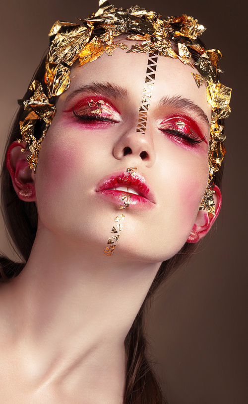 Vogue style portrait of a woman with gold makeup.