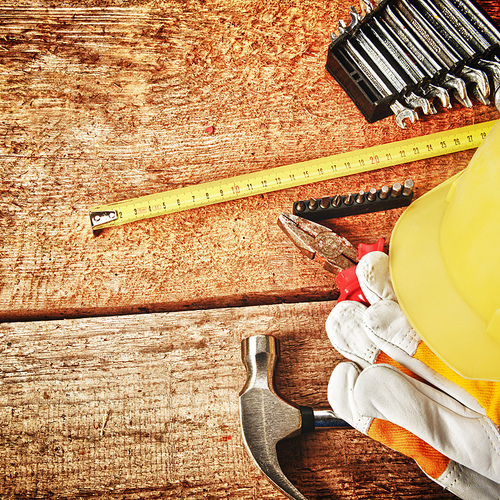 Different tools and gloves on  wooden background.