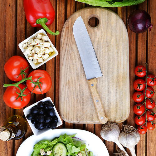 salad with feta cheese and fresh vegetables on wooden background