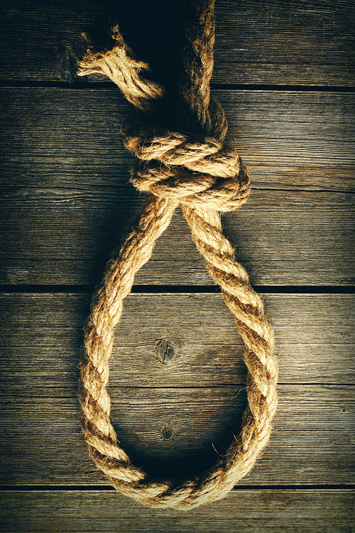 Rope noose with knot over old wooden background