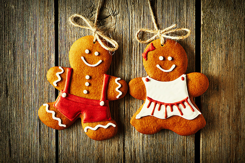 Christmas homemade gingerbread couple cookies over wooden background