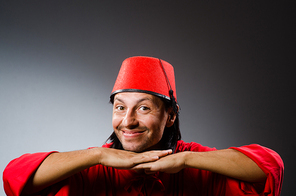 Funny man in red dress wearing fez hat