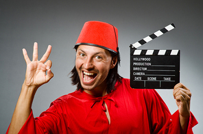 Man wearing fez hat with movie board