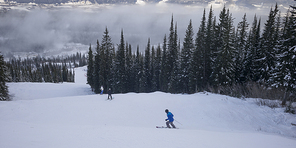 Tourists skiing in valley,  Kicking Horse Mountain Resort, Golden, British Columbia, Canada
