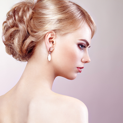 Portrait of beautiful sensual woman with elegant hairstyle.  Perfect makeup. Blonde girl. Fashion photo. Jewelry and dress