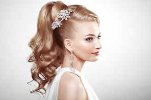 Fashion portrait of young beautiful woman with jewelry and elegant hairstyle. Blonde girl with long wavy hai. Perfect make-up.  Beauty style woman with diamond accessories