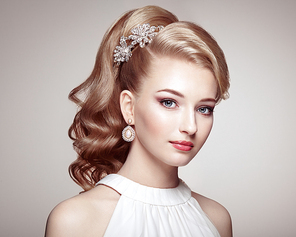 Fashion portrait of young beautiful woman with jewelry and elegant hairstyle. Blonde girl with long wavy hai. Perfect make-up.  Beauty style woman with diamond accessories