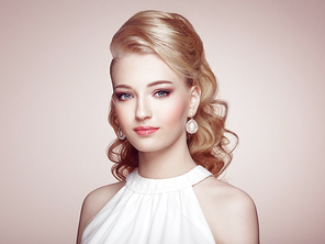 Fashion portrait of young beautiful woman with jewelry and elegant hairstyle. Blonde girl with long wavy hai. Perfect make-up.  Beauty style woman with diamond accessories