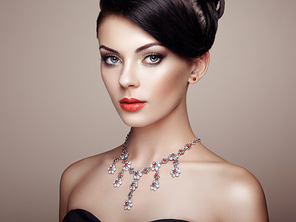 Fashion portrait of young beautiful woman with jewelry. Brunette girl. Perfect make-up.  Beauty style woman with diamond accessories