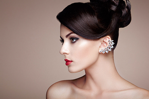 Fashion portrait of young beautiful woman with jewelry and elegant hairstyle. Brunette girl. Perfect make-up.  Beauty style woman with diamond accessories