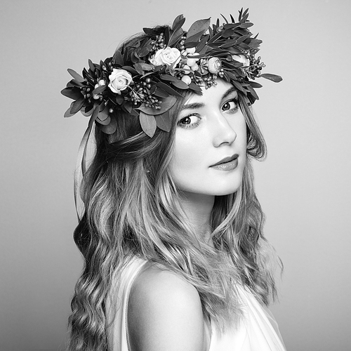 Beautiful blonde woman with flower wreath on her head. Beauty girl with flowers hairstyle. Perfect makeup. Beauty fashion. Spring woman. Black and White