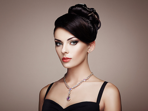 Fashion portrait of young beautiful woman with jewelry and elegant hairstyle. Brunette girl. Perfect make-up.  Beauty style woman with diamond accessories