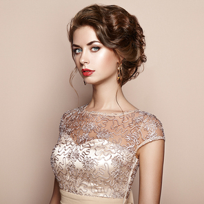 Fashion portrait of beautiful woman in elegant dress. Girl with elegant hairstyle and jewelry