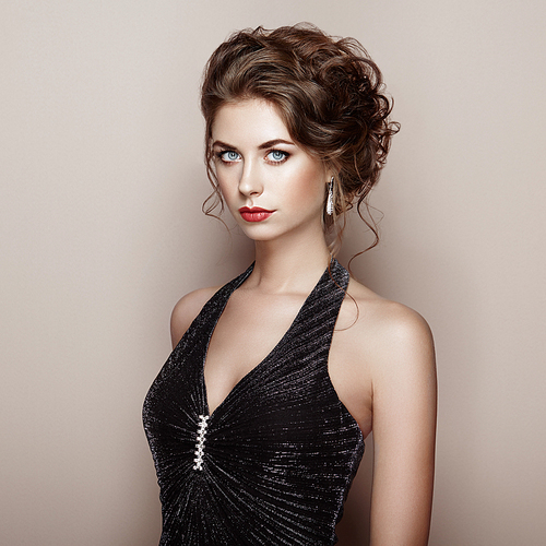 Fashion portrait of beautiful woman in elegant dress. Girl with elegant hairstyle and jewelry