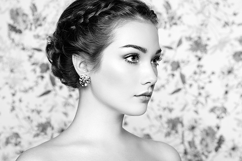 Portrait of young beautiful woman on a background of flowers. Fashion photo. Jewelry and hairstyle. Perfect makeup. Black and White