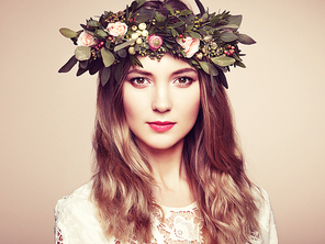 Beautiful blonde woman with flower wreath on her head. Beauty girl with flowers hairstyle. Perfect makeup. Beauty fashion. Spring woman