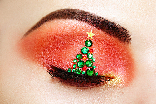 Eye girl makeover christmas tree. Winter christmas makeup. Beauty fashion. Eyelashes. Cosmetic Eyeshadow. Makeup detail. Creative woman holiday make-up