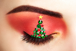 Eye girl makeover christmas tree. Winter christmas makeup. Beauty fashion. Eyelashes. Cosmetic Eyeshadow. Makeup detail. Creative woman holiday make-up