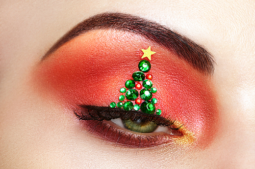 Eye girl makeover christmas tree. Winter christmas makeup. Beauty fashion. Eyelashes. Cosmetic Eyeshadow. Makeup detail. Creative woman holiday make-up