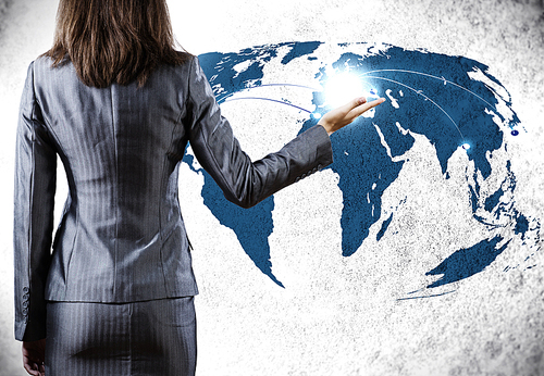 Rear view of businesswoman pointing at world map