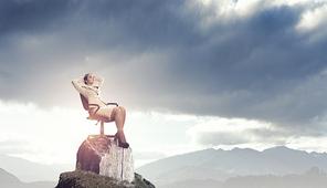 Young relaxed businesswoman sitting relaxed in chair and dreaming