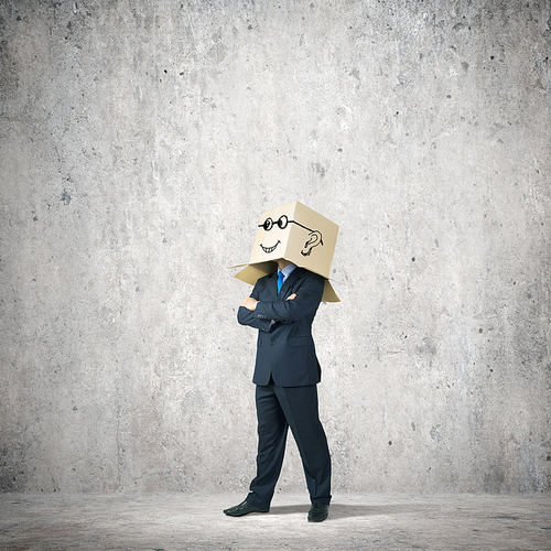 Businessman wearing carton box with smileys on head