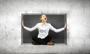 Young woman trapped in stone cube in wall