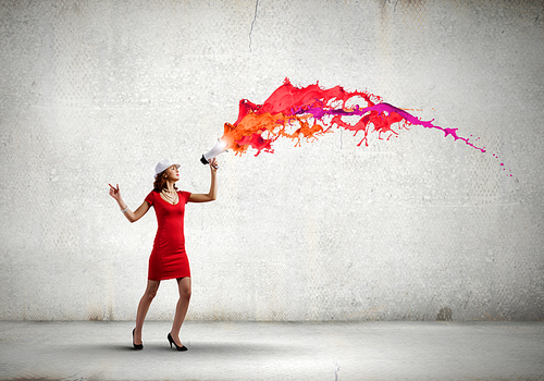 Pretty woman in red dress screaming in megaphone