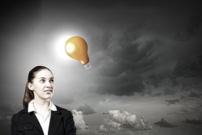 Concept of creativity with woman and light bulb hanging from above