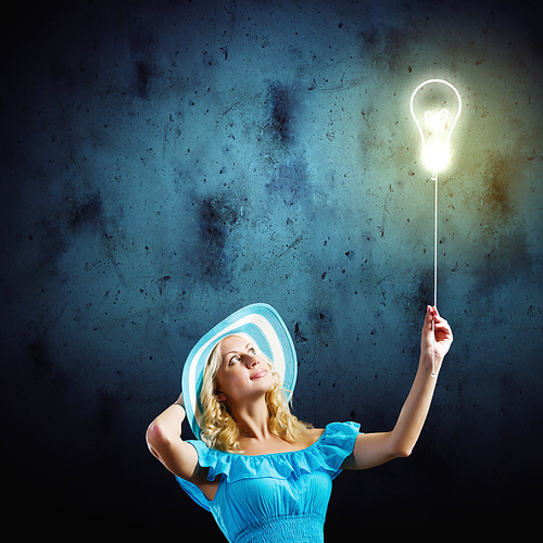 Young pretty blond in blue hat and dress holding balloon