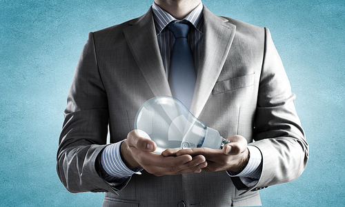 Close up of businessman hands holding glass light bulb