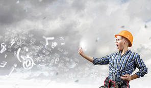 Young emotional woman mechanic screaming in mobile phone