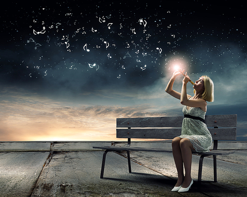 Young woman sitting on bench and playing fife