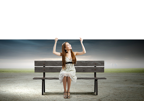 Young asian woman sitting on bench with blank banner