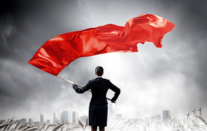 Young determined businesswoman with red flag in hands
