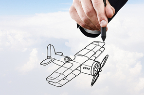 Person hand drawing old airplane on sky background
