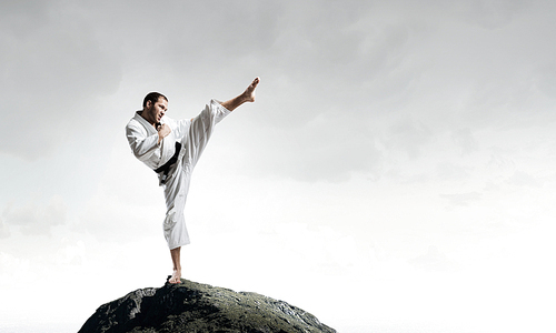 Young determined karate man on top high in sky