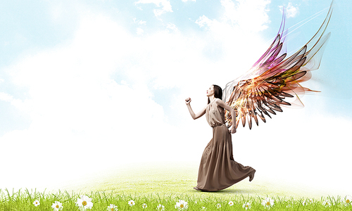 Attractive woman running with angel wings behind back
