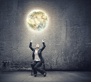 Image of businesswoman holding earth planet in hands above head. Elements of this image are furnished by NASA