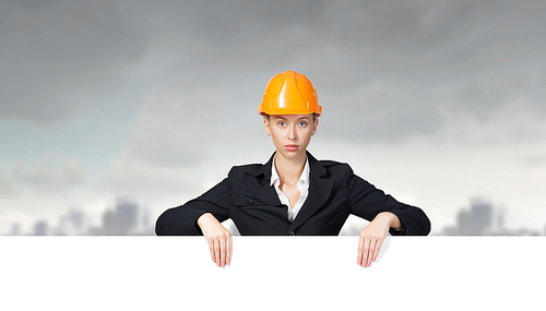 Attractive woman builder demonstrating white blank banner