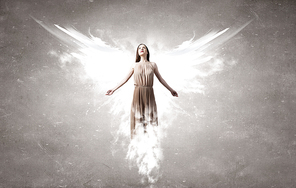 Attractive woman with angel wings on concrete background