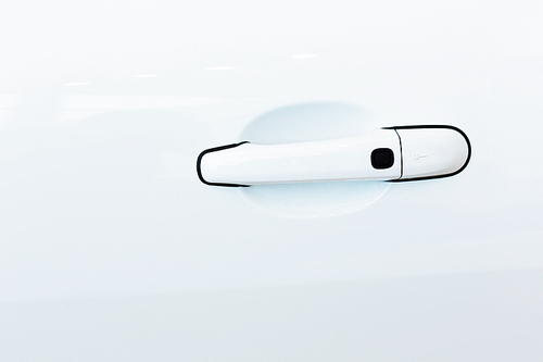 Close up image of white car door handle