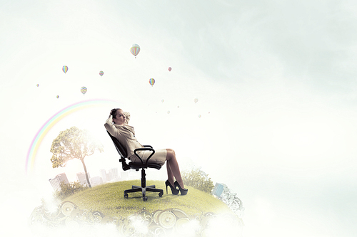 Young relaxed businesswoman sitting relaxed in chair and dreaming