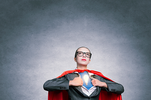 Businesswoman wearing red cape and opening her shirt like superhero