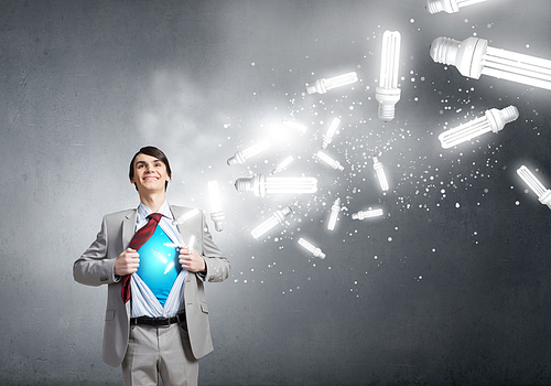 Young smiling businessman acting like super hero and tearing his shirt off